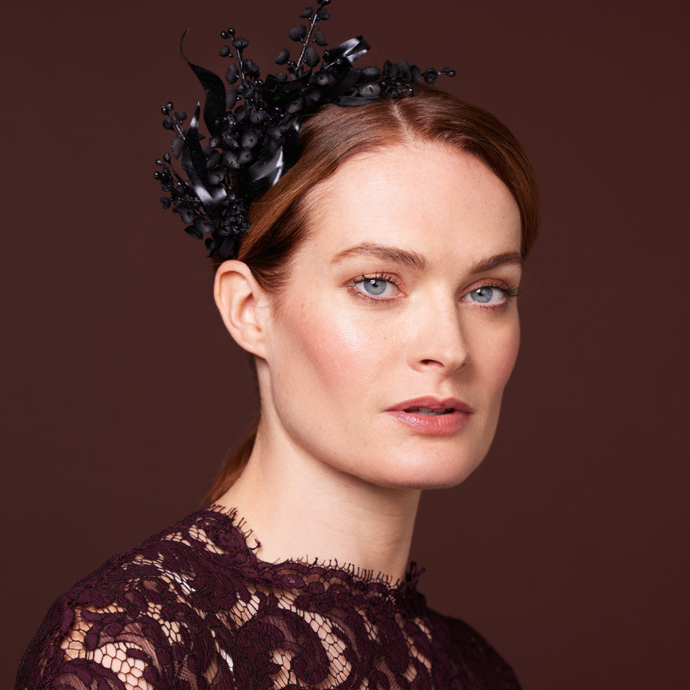 Woman wearing a dress with a black half lily of the valley headband