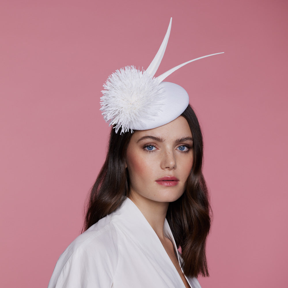 White straw pillbox with pom and feather