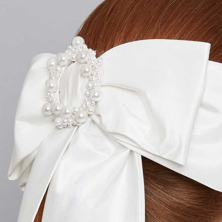 Close up of the ivory silk bow comb with pearl beading