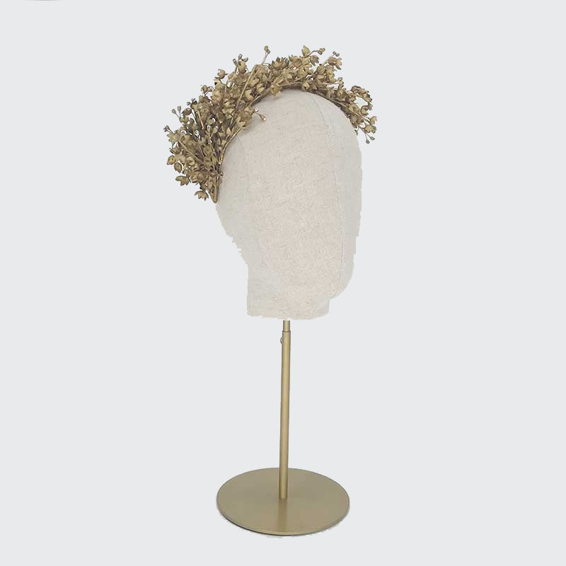 Side view of a gold Lily of the Valley headdress on a linen display head