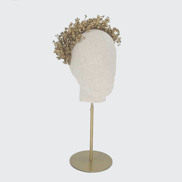 Side view of a gold Lily of the Valley headdress on a linen display head