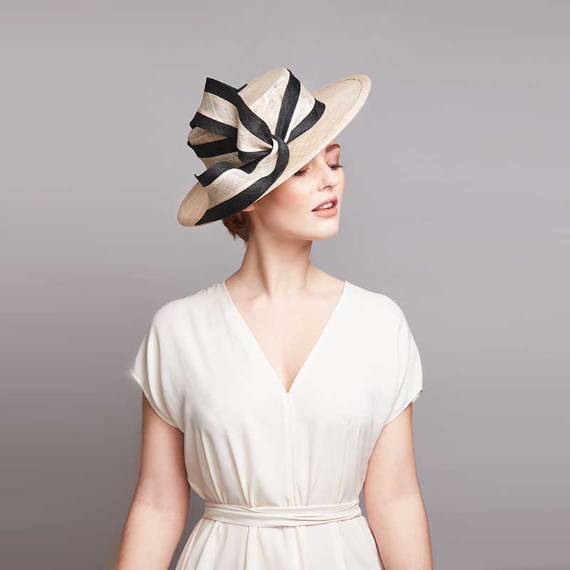 Woman wearing a white dress and a natural boater with a striped sweep