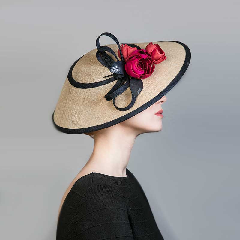 Woman wearing a black dress and a natural CHarlene with a navy edge, red roses and a bow