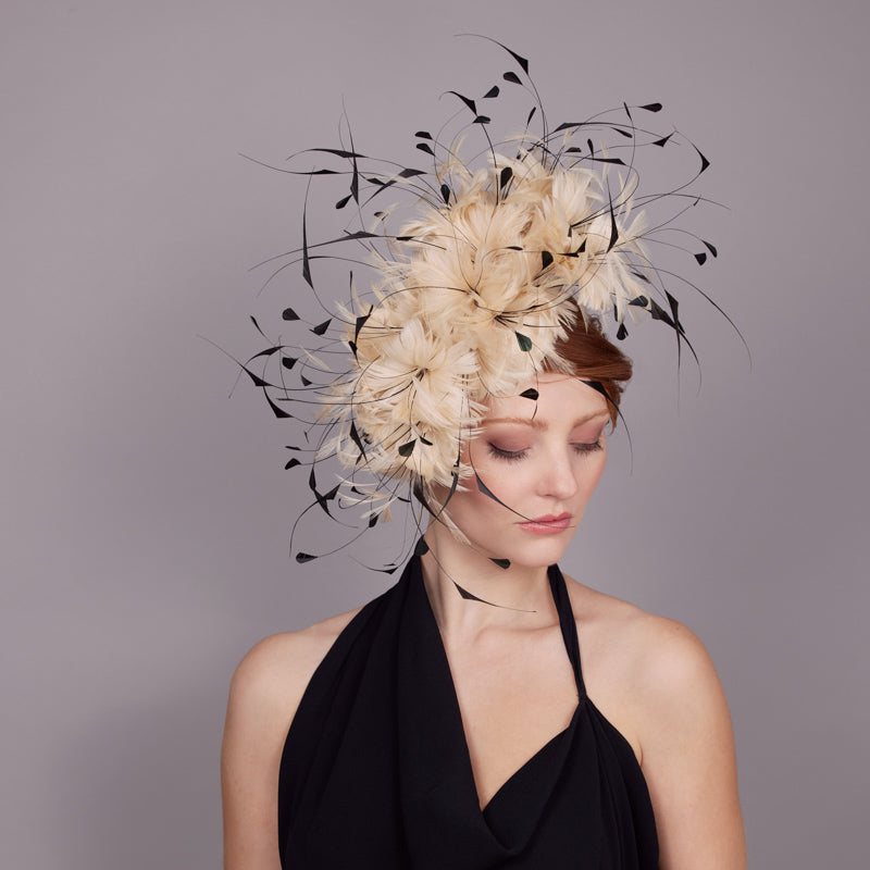 Woman wearing a black dress and a natural feather flower pillbox with black inserts