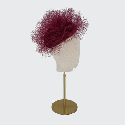 Photo of a burgundy veiling bomb pillbox on a linen display head
