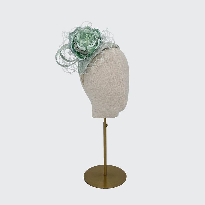 Pale green feather crescent with a silk flower and veiling