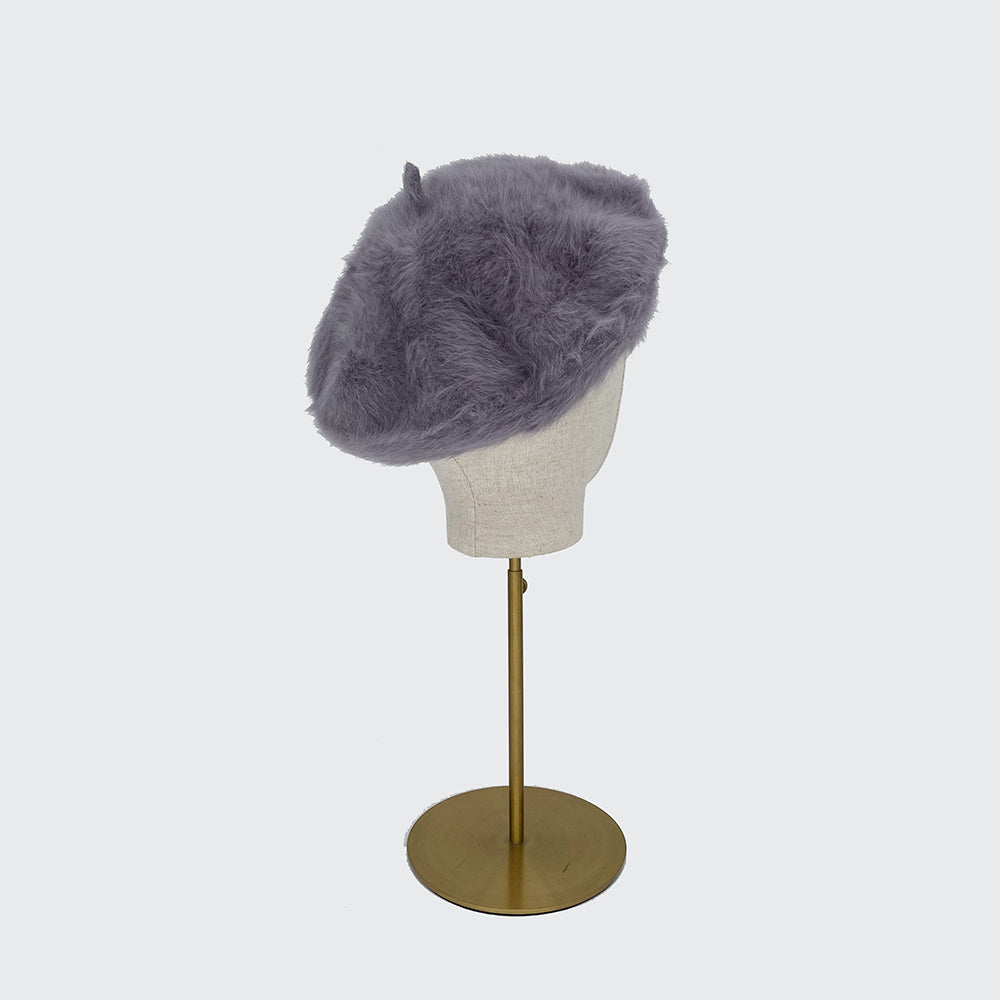 Photo of a silver grey angora beret on a linen display head