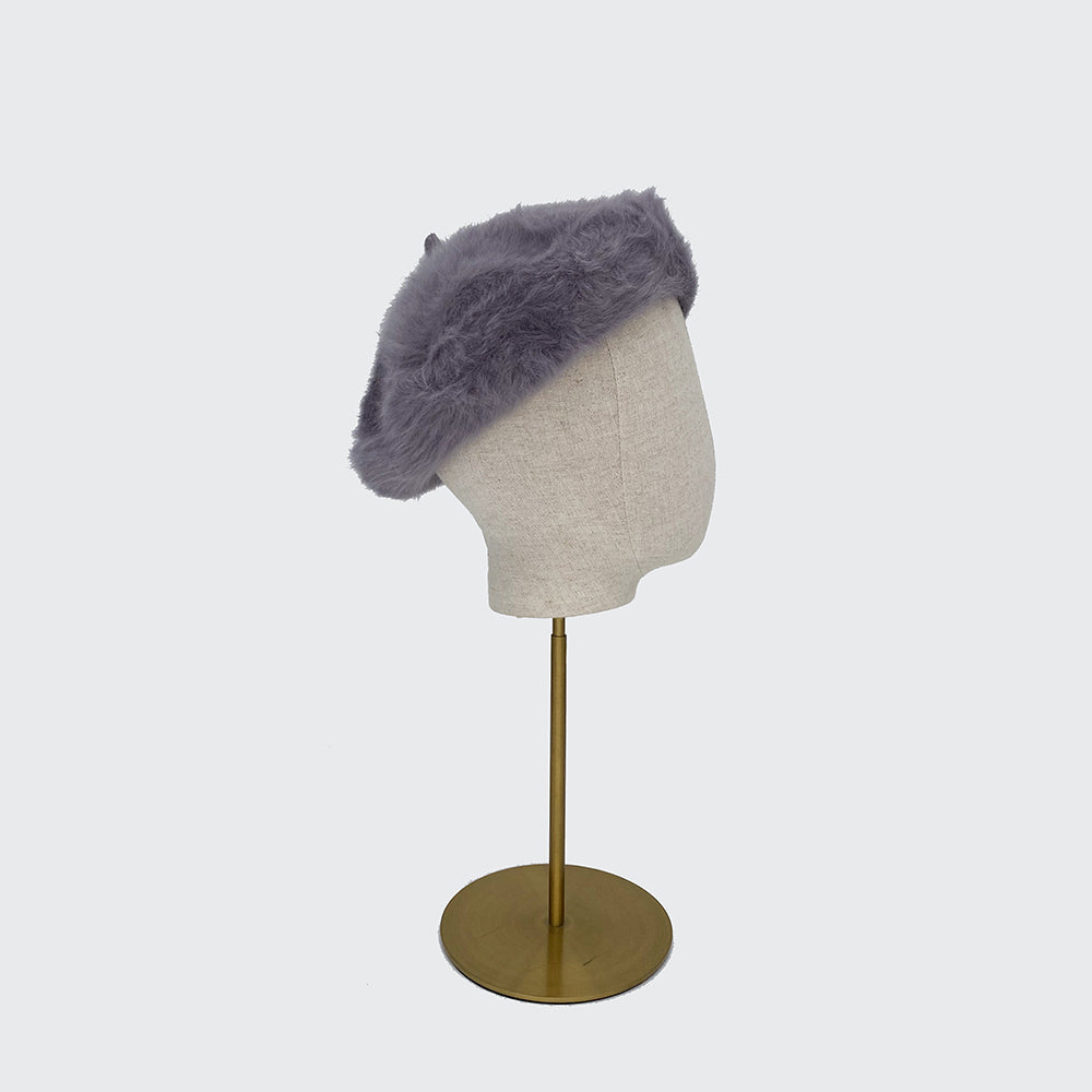 Side view of a silver grey angora beret on a linen display head