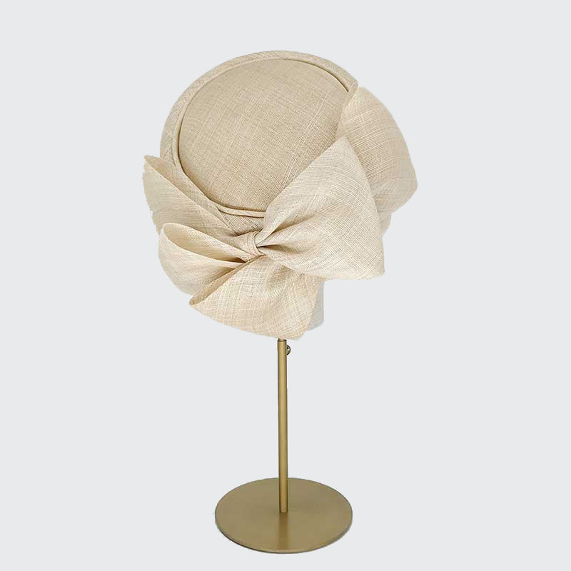 Photo of a natural fine straw Jackie O pillbox with bows on a linen display head