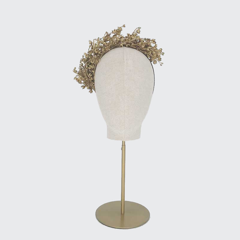 Photo of a gold Lily of the Valley headdress on a linen display head