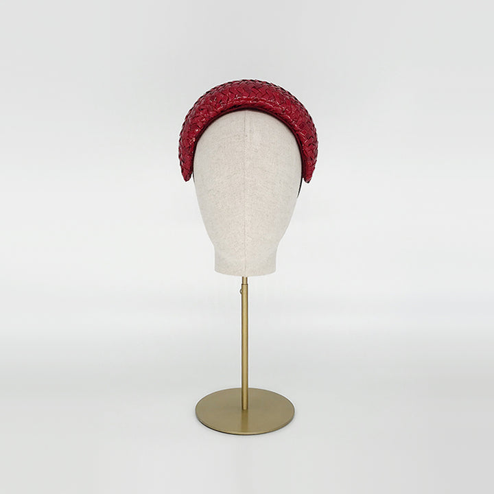 Photo of a red patent wide headband on a linen display head