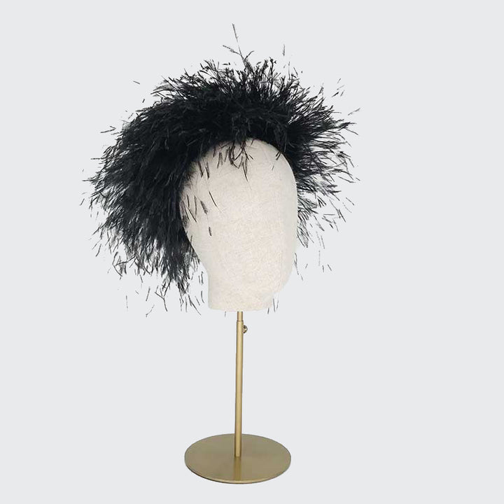 Side view of a black ostrich feather Jackie O pillbox on a linen display head