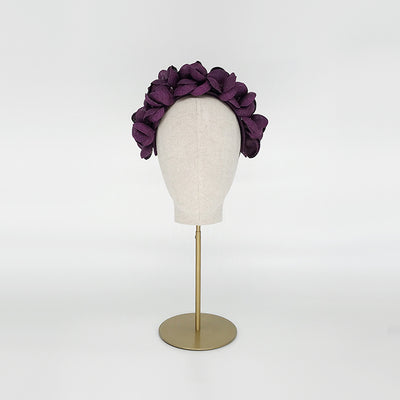 Photo of a purple grazia petal headdress on a linen display head