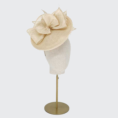 Photo of a natural straw disc with bows on a linen display head