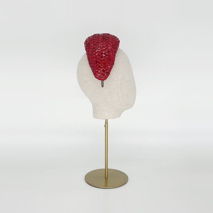 Side view of a red patent wide headband on a linen display head