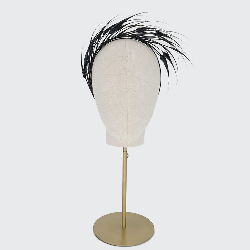 Photo of a black diamond-cut feather headband on a linen display head