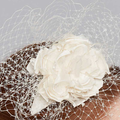 Close up of a silk flower crescent with birdcage veil