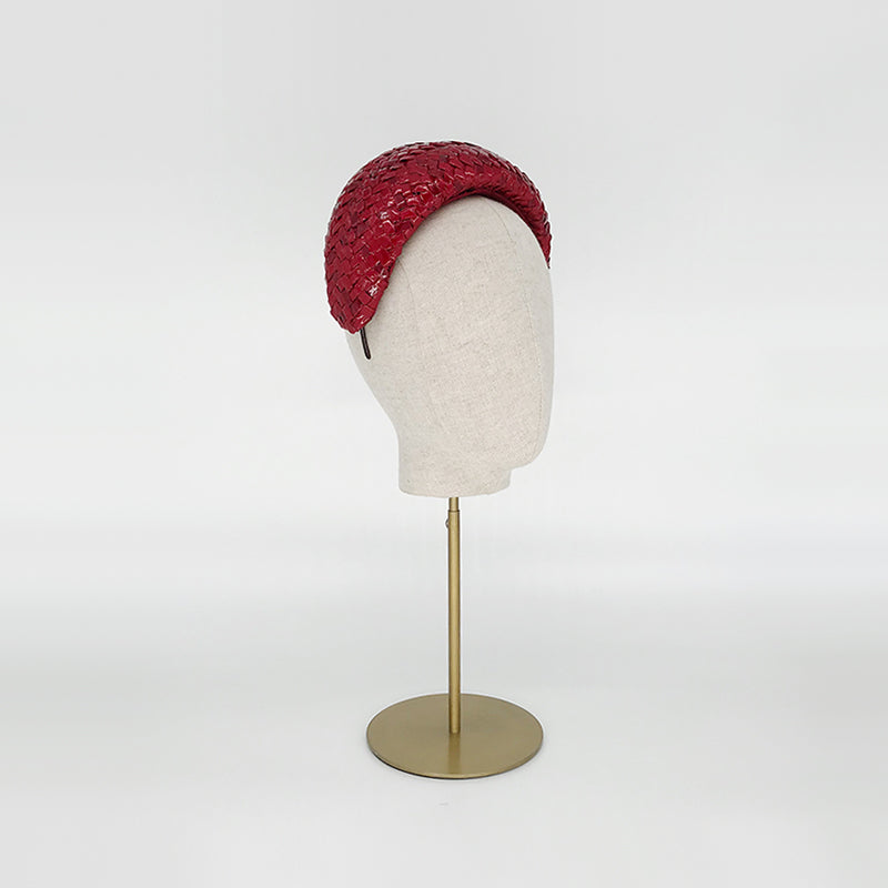 Side view of a red patent wide headband on a linen display head