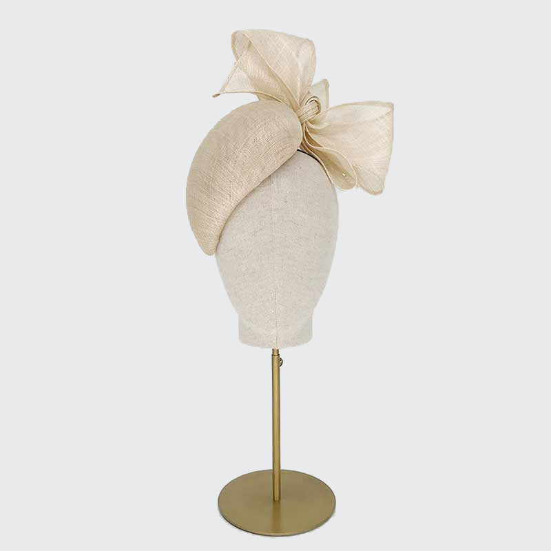 Photo of a natural fine straw teardrop pillbox with bows on a linen display head