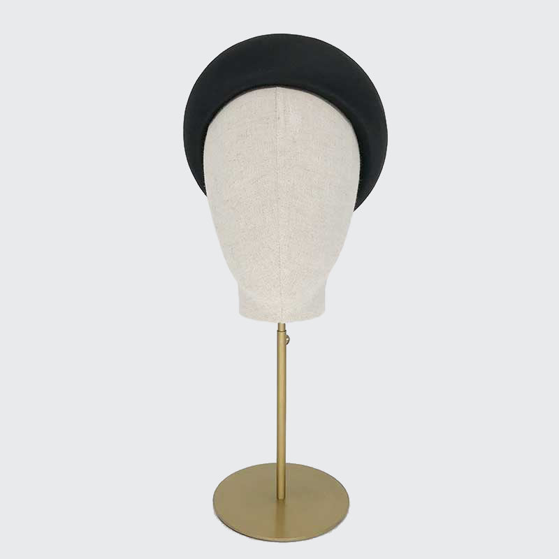Photo of a black silk Jackie O pillbox on a linen display head