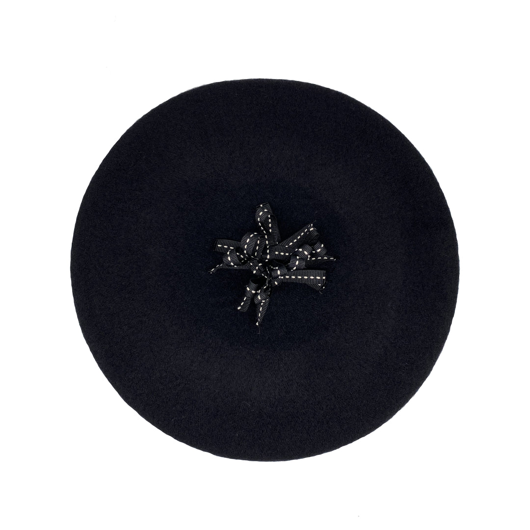 Photo of a black wool beret with a black ribbon pom