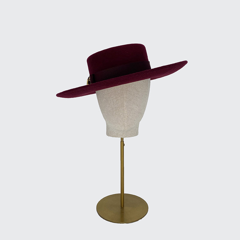Photo of a burgundy wool fedora and gold stars on a linen display head