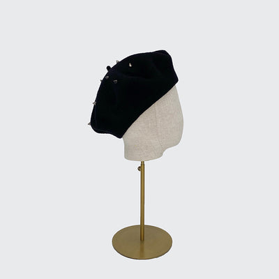 Side view of a black wool beret with studs