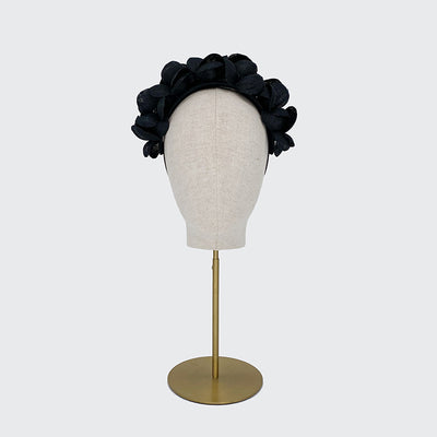 Photo of a black fine straw petal headband on a linen display head