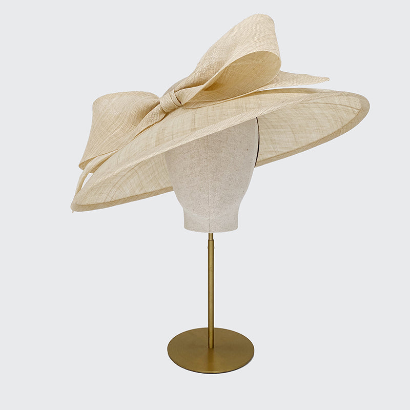 Photo of a natural fine straw sweep bell with a bow on a linen display head