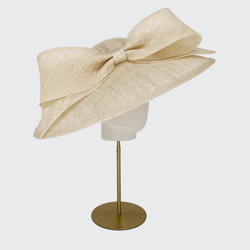 Photo of a natural fine straw sweep bell with a bow on a linen display head