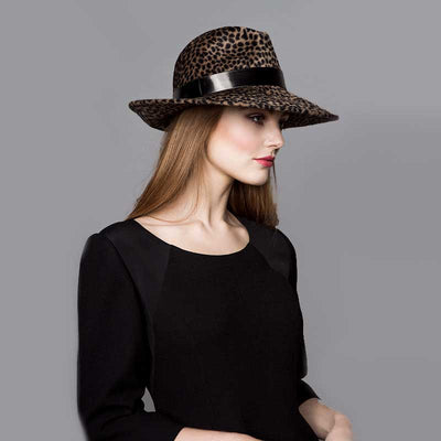 Woman wearing a black dress and a cheetah print velour felt fedora with a black patent band