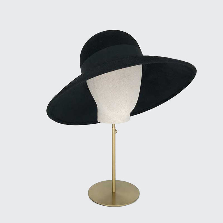 Side view of black velour felt downbrim with a grosgrain band on a linen display head