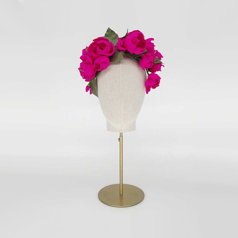 Photo of a hot pink silk rose headdress on a linen display head