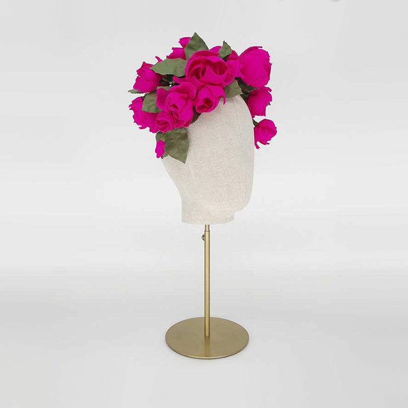Side view of a hot pink silk rose headdress on a linen display head