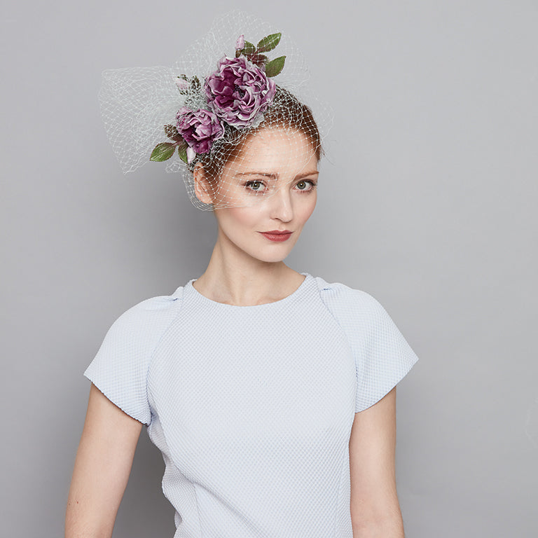 Photo a woman wearing a pale blue dress and  a purple dip-dyed silk roses headband with veiling
