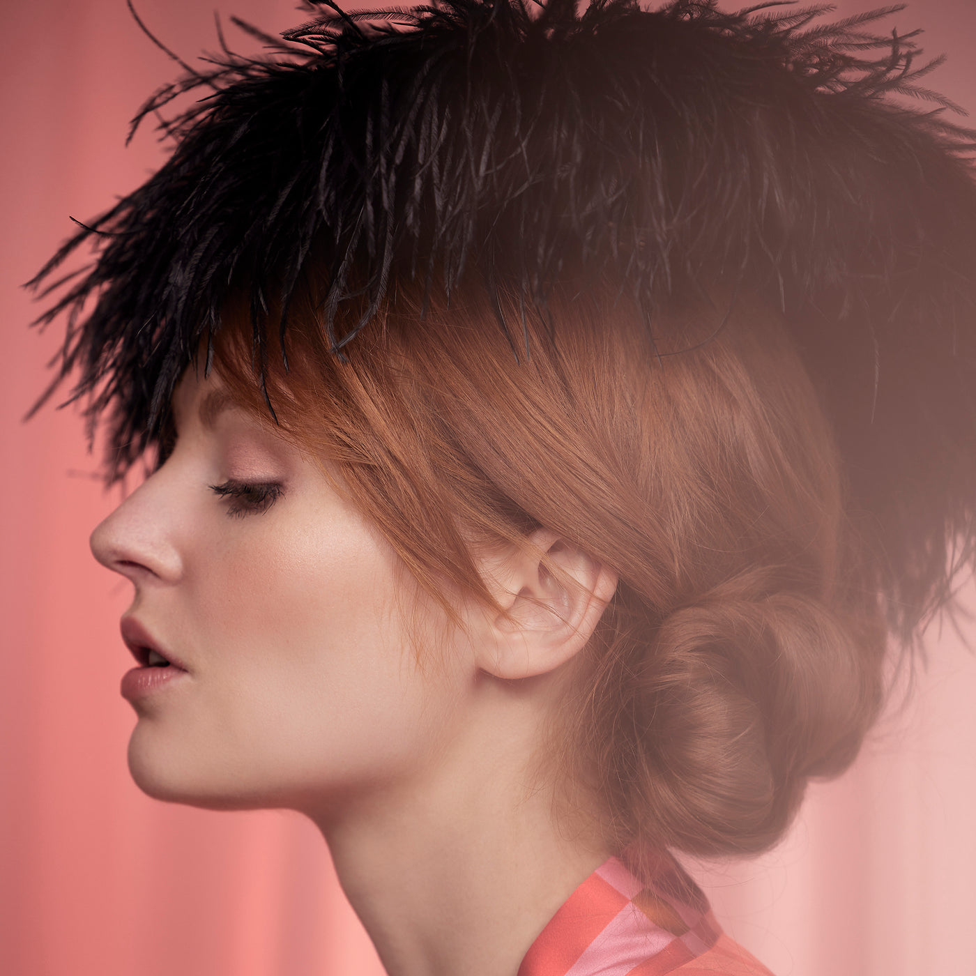 Woman with red hair wearing a black ostrich feather disc