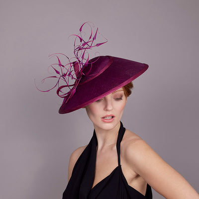 Woman with red hair wearing a black dress and a deep magenta straw Charlene with fine curled feathers