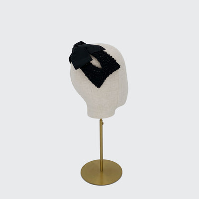 Photo of a black silk beaded bow headband on a linen display head