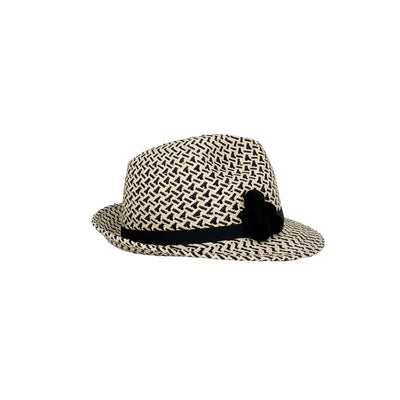 Side view of a natural and black pattern trilby with pom poms