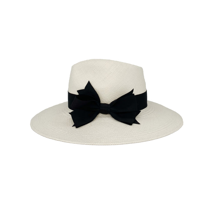 Side view of a bleached white panama fedora with a black grosgrain bow