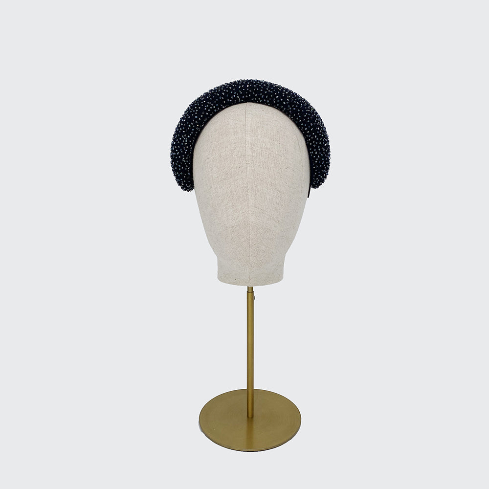 Photo of a navy silk beaded wide crescent headband on a linen display head