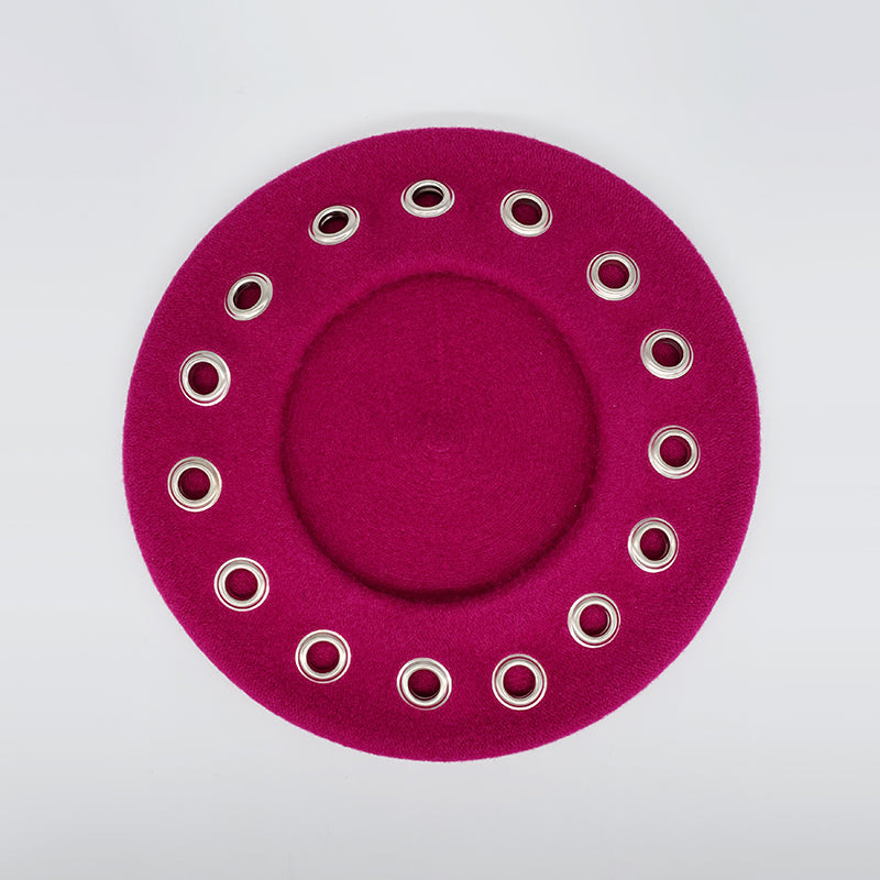 Photo of a magenta pink wool beret with eyelets