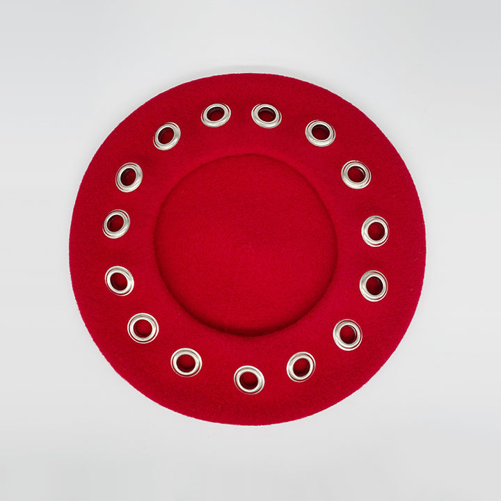 Photo of a red wool beret with eyelets